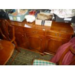 A contemporary Mahogany crossbanded with Yewwood finished breakfront Sideboard having two short and