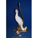 An old Table lamp in the form of a white ceramic bird standing on a rocky outcrop,