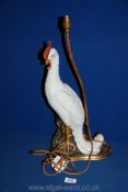 An old Table lamp in the form of a white ceramic bird standing on a rocky outcrop,