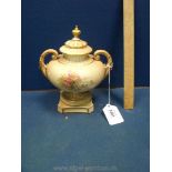 A two handled Royal Worcester Urn with lid in blush colour.