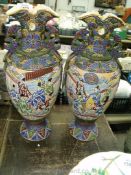 Two oriental Japanese vases with embossed decoration and oriental scenes. One vase has a chip.