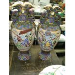 Two oriental Japanese vases with embossed decoration and oriental scenes. One vase has a chip.