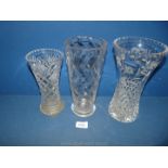 Three cut glass vases, one Edinburgh crystal; two at 10" tall and the smallest one at 8 1/4" tall.