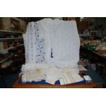 A box of tablecloths, cream tapestry with orange/brown border and matching serviettes, etc.