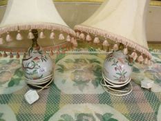 A pair of Chinese style ginger jar table lamps decorated with flora and peaches completed with two