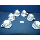 Six blue and white chocolate cups with acorn finials to the lids.