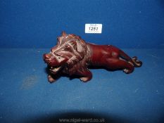 A small carved wood Lion, 7'' long by 3 1/2'' tall,