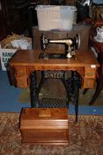 A Singer Treadle sewing Machine, with drawers complete with contents including machine accessories,
