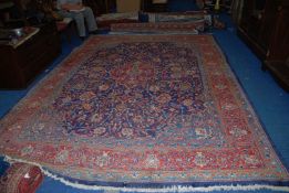 A large contemporary Iranian bordered, patterned and fringed Rug,