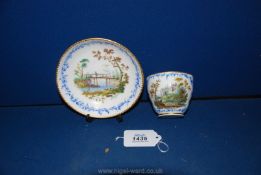 A rare Sevres cup and a saucer each finely painted with landscape scenes in the early style,
