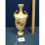 A Royal Worcester Vase having mask design handles painted with flowers.