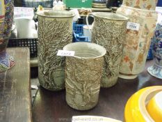 Three Tregaron Cymru pottery Vases decorated with trees and gate in relief, two being 9" all,