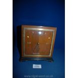 An Art Deco style mantle Clock of square form having quarter-veneered face with Roman numerals at