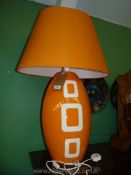 A large orange Louis Drimmer table Lamp and matching shade.