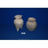 A Chinese Neolithic buff-coloured earthenware tripod container with faint ribbing to the body,