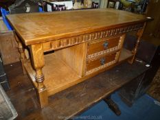 A medium oak finished Coffee Table on turned legs and having a central section with two short