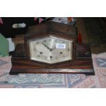 A dark Oak finished Art Deco style mantel Clock having a compressed hexagonal face with Arabic