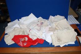 A box of mixed embroidered Portuguese serviettes, handkerchiefs, red bag containing crochet work,