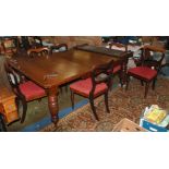 An Edwardian mahogany/ walnut wind out extending Dining Table standing on turned and fluted legs
