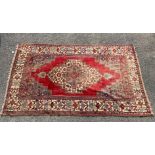 An Eastern bordered, patterned and fringed Rug, in red, blue and cream colourway,