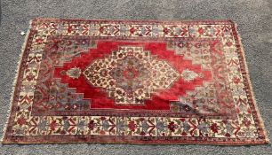 An Eastern bordered, patterned and fringed Rug, in red, blue and cream colourway,