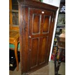 A Georgian Oak wall hanging Corner Cupboard having four recessed panels to the door with original