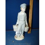 A Lladro figure of a boy carrying two pails of water.