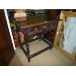 A most appealing and collectable dark oak Jacobean side table standing on turned legs united by
