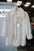 An 'Olsen Collections' cream fur Coat, knee length with turned up cuffs, size 12.
