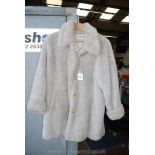 An 'Olsen Collections' cream fur Coat, knee length with turned up cuffs, size 12.