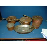 A quantity of copper pans and skillet, some with brass handles.