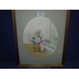 A framed and oval mounted watercolour depicting a still life vase of flowers, signed lower right J.