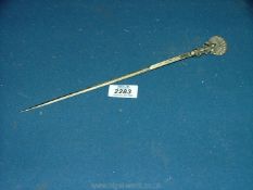 An Indian white metal skewer with peacock finial.