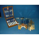 A cased set of stainless steel dinner knives and forks together with horn handled steak knives,
