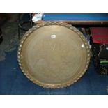 A large brass plaque/Benares table top with Moorish style decoration and pie crust style rim,