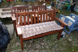 A wooden bench and two matching chairs,