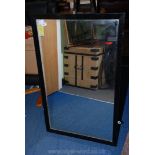 A large wooden framed mirror. 45" x 27 1/2".