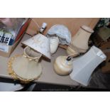 A quantity of pottery table lamps and shades.