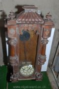 A hardwood wall hanging pendulum clock with enamel face and Roman numerals. A/F.