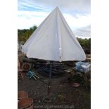 A hand cranked garden parasol with metal pierced base.