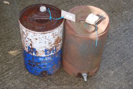 Two old metal oil drums, one with tap.