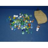 A quantity of miscellaneous small and large marbles, together with a pea whistle.