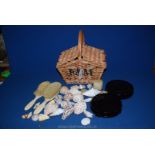 A small Fortnum & Masons wicker basket with small shells, two cream plastic brushes,