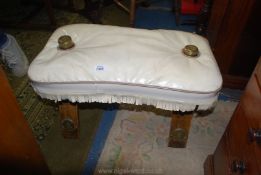 A cream upholstered seated folding Camel Saddle with brass frame cups and plaques,