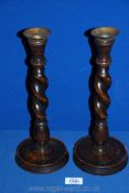 A pair of wooden barley twist Candlesticks with metal holders.