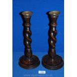 A pair of wooden barley twist Candlesticks with metal holders.