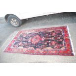 A bordered patterned and fringed Rug in red, blue and black with geometric designs, 48" x 89".