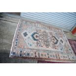 A bordered patterned and fringed Rug in green, cream and brown geometric pattern, some wear,