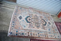 A bordered patterned and fringed Rug in green, cream and brown geometric pattern, some wear,