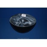 A black glass bowl with white swirl, 8 1/2" diameter x 4 1/2" high.